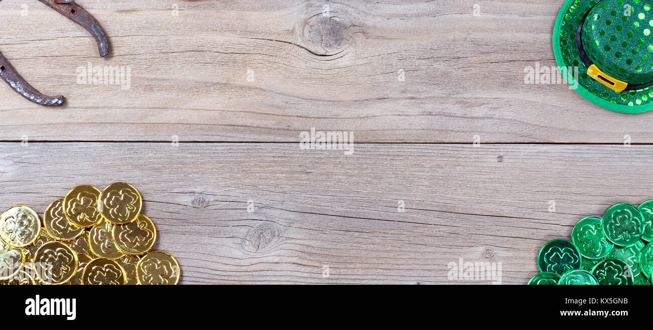 Lucky Green hat, a ferro di cavallo e monete d'oro per St Patrick in ogni angolo rustico di tavole di legno in vista aerea Foto Stock