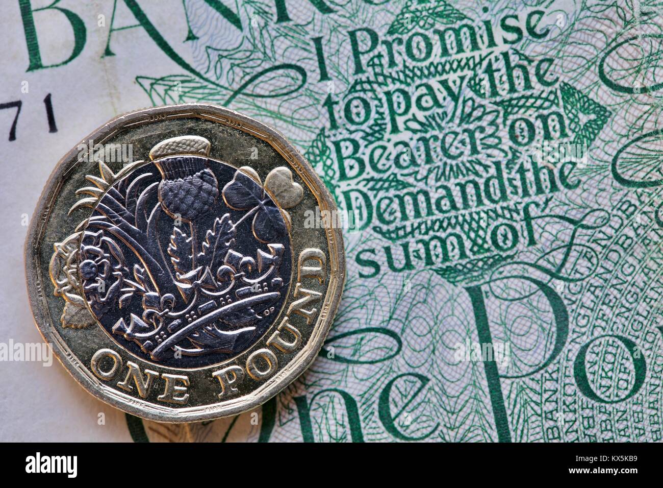 Una sterlina moneta su un 1960s £ 1 nota con la promessa di pagare il portatore on demand la somma di una libbra Foto Stock