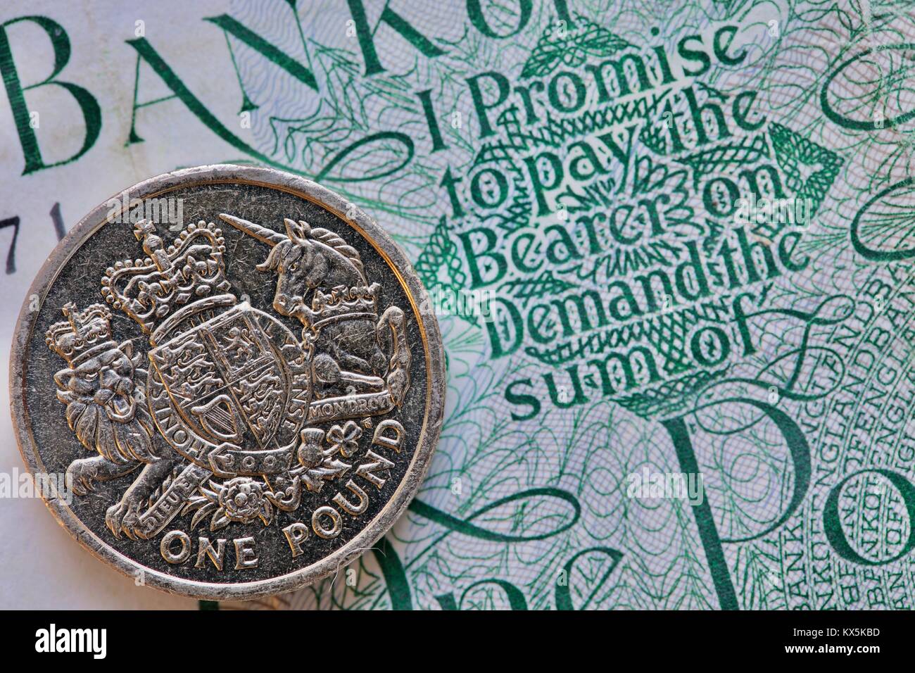 Una sterlina moneta su un 1960s £ 1 nota con la promessa di pagare il portatore on demand la somma di una libbra Foto Stock