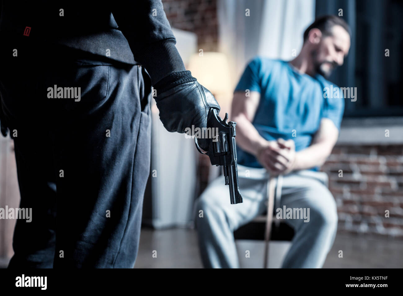 Criminale violenta con una pistola e un intimidito l uomo Foto Stock