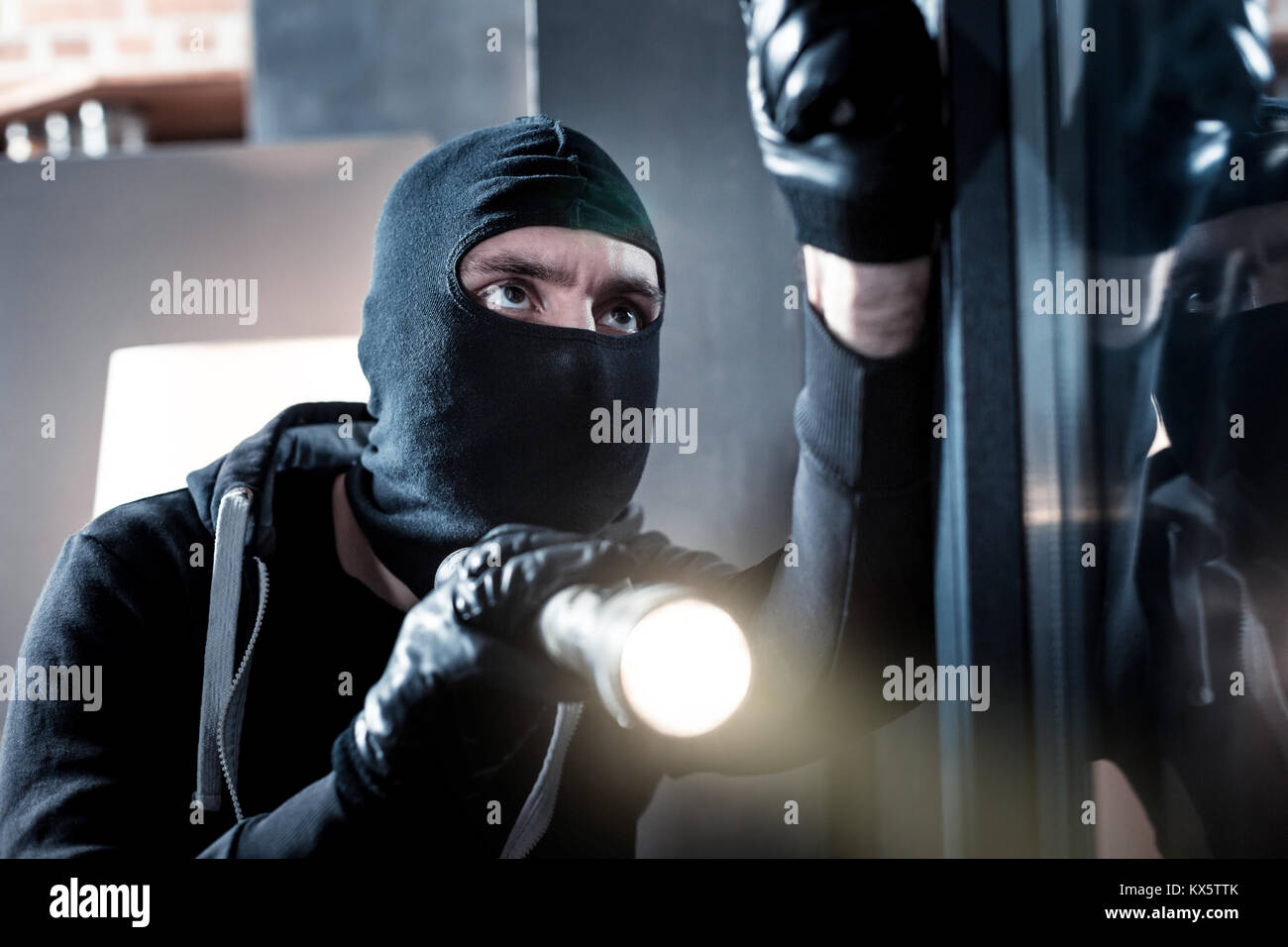Masked scassinatore tenendo una torcia Foto Stock