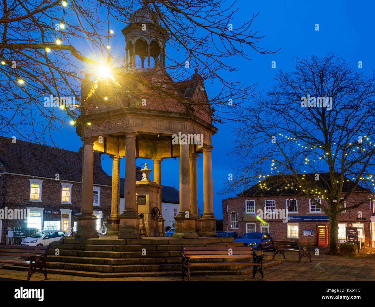 Vecchia pompa d'acqua o mercato noto come la Fontana In St James Square a Dusk Boroughbridge North Yorkshire England Foto Stock