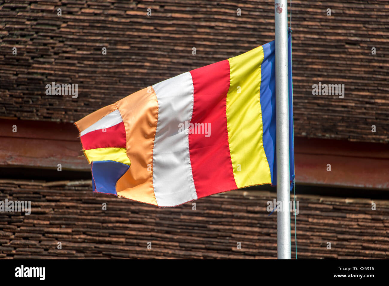 Battenti Standard' Bandiera buddista sullo sfondo del tetto nel tempio buddista. L'Iva Phramahathat Rajbovoravihane tempio a Luang Prabang, Laos. Foto Stock