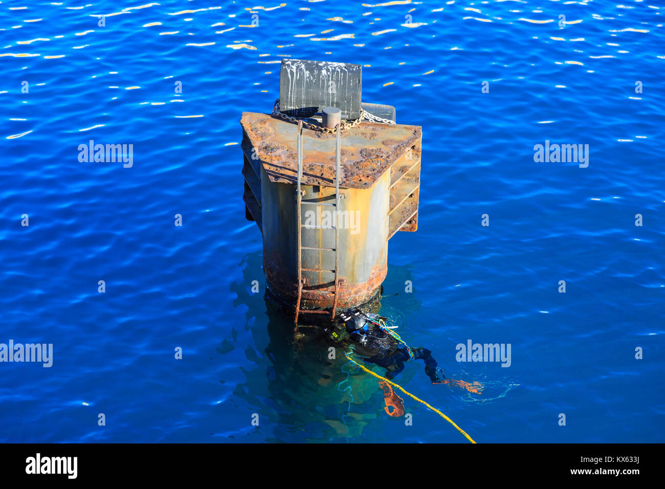 Subacqueo ad esplorare una piattaforma arrugginito e immersioni nell'azur acque blu del mar Mediterraneo, Francia, Europa Foto Stock