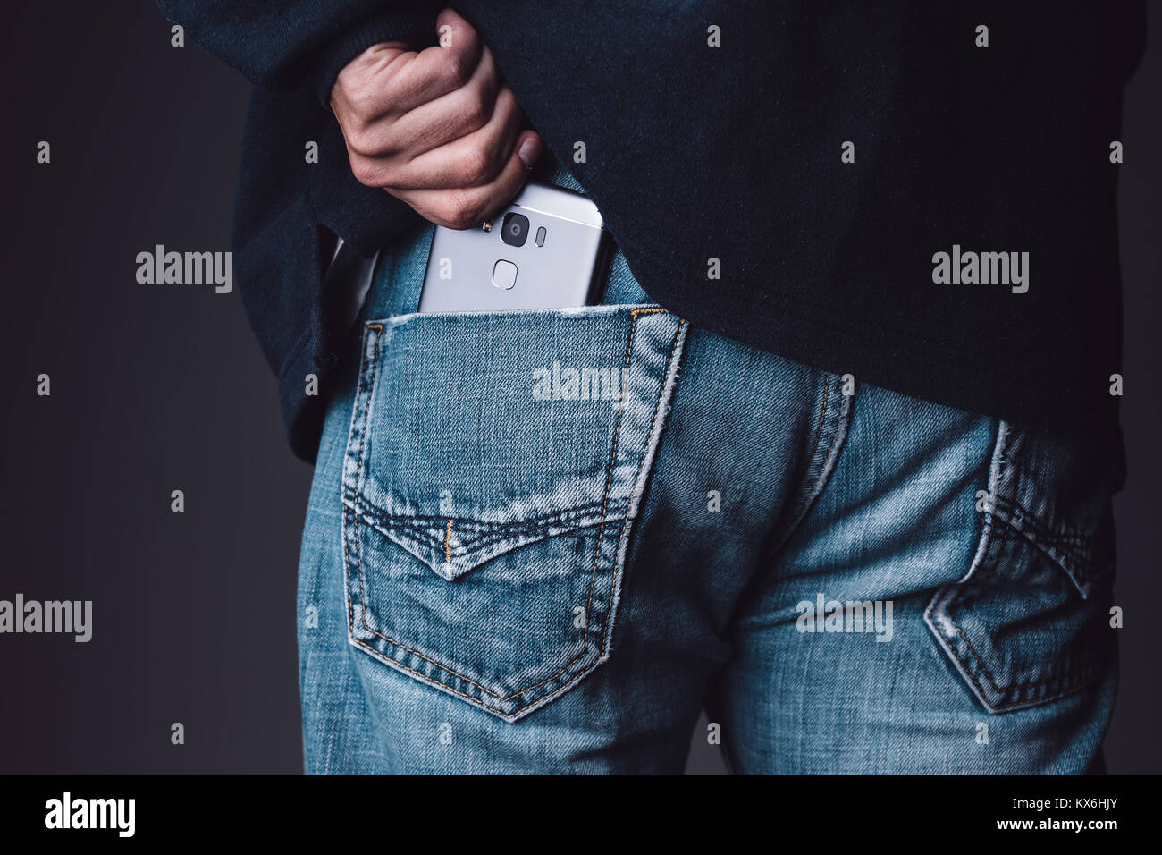 Smartphone su un caucasian giovane maschio tasca dei jeans Foto Stock