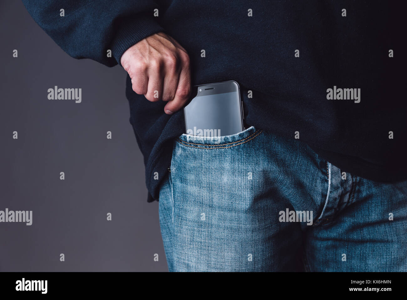 Smartphone su un caucasian giovane maschio tasca dei jeans Foto Stock