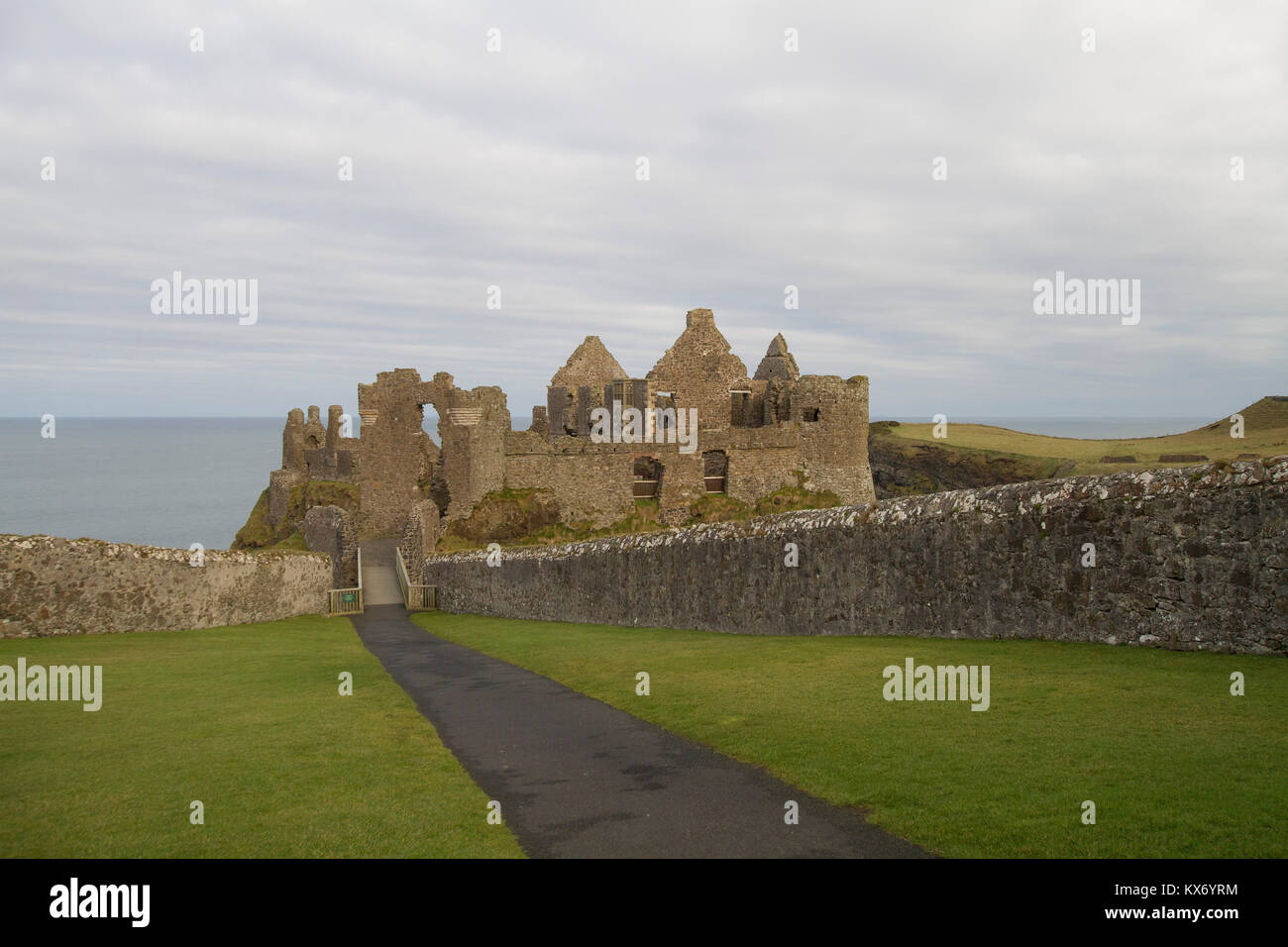 Il visitatore entrata alle rovine del castello di Dunluce sulla contea di Antrim coast. Dunluce Castle è un famoso castello da visitare in Irlanda del Nord. Foto Stock