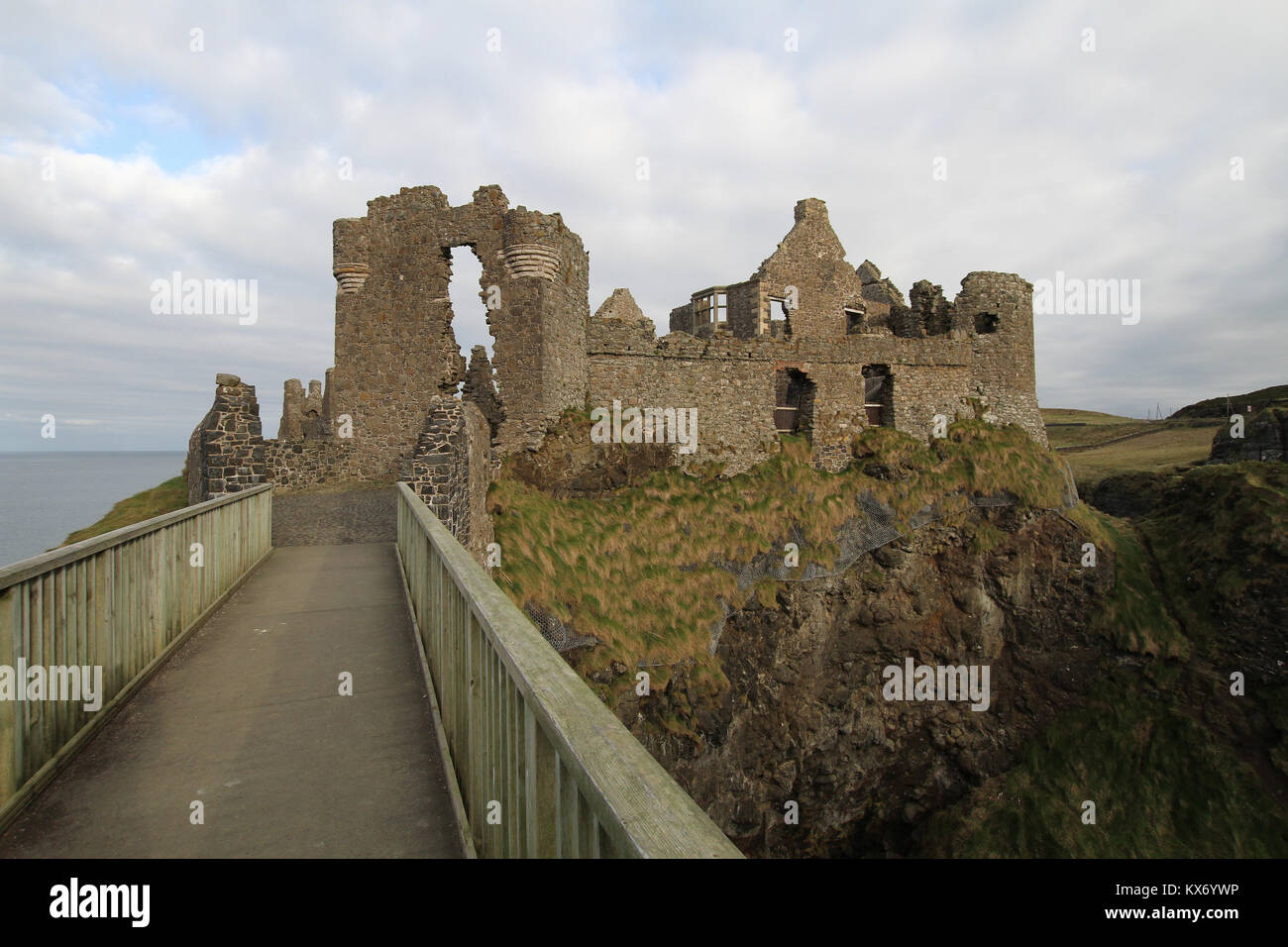 Il visitatore entrata alle rovine del castello di Dunluce sulla contea di Antrim coast. Dunluce Castle è un famoso castello da visitare in Irlanda del Nord. Foto Stock