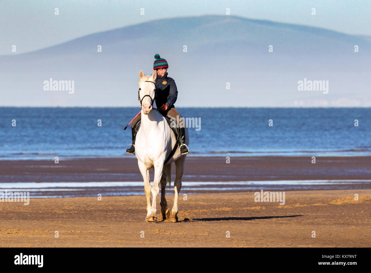 Cavallo Cavaliere, Spiaggia di Cleveleys Lancashire. 8 gennaio 2018. Regno Unito Meteo. Deborah Simmonds mette il suo amato Cavallo, 4 anno vecchio 'Scooby' attraverso i suoi passi come egli trot attraverso la marea entrante nel glorioso sole invernale lungo le rive di Cleveleys beach in Lancashire. Credito: Cernan Elias/Alamy Live News Foto Stock