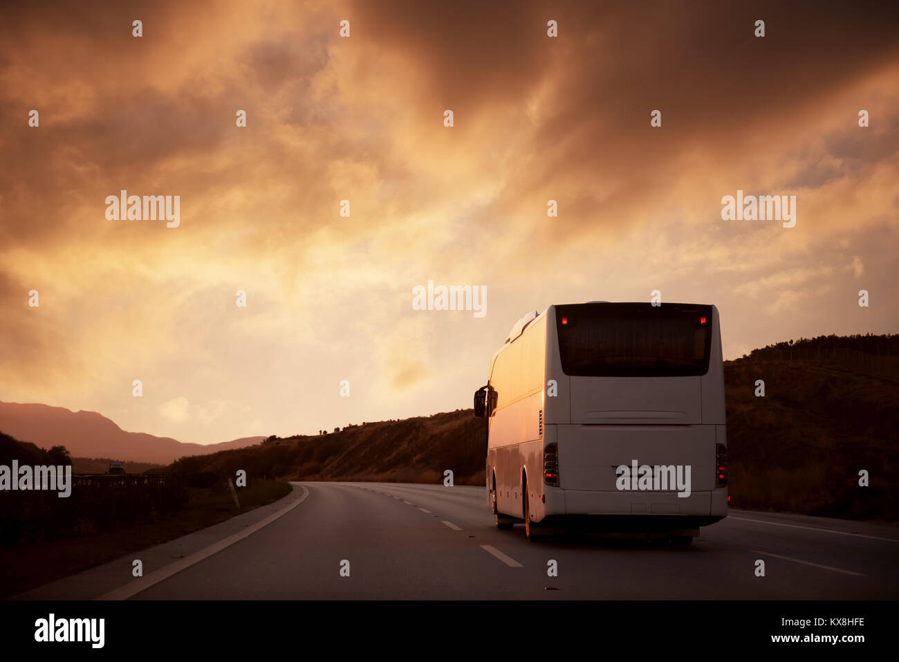 Bus bianco guida su strada con vista tramonto Foto Stock