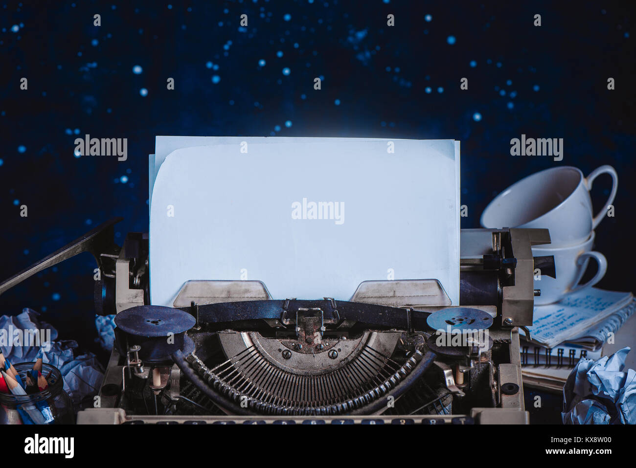 Nastri inchiostratori per macchine da scrivere moderne con fogli di carta su uno sfondo scuro. Editing e copywriting workplace. Scrittura creativa del concetto. Foto Stock