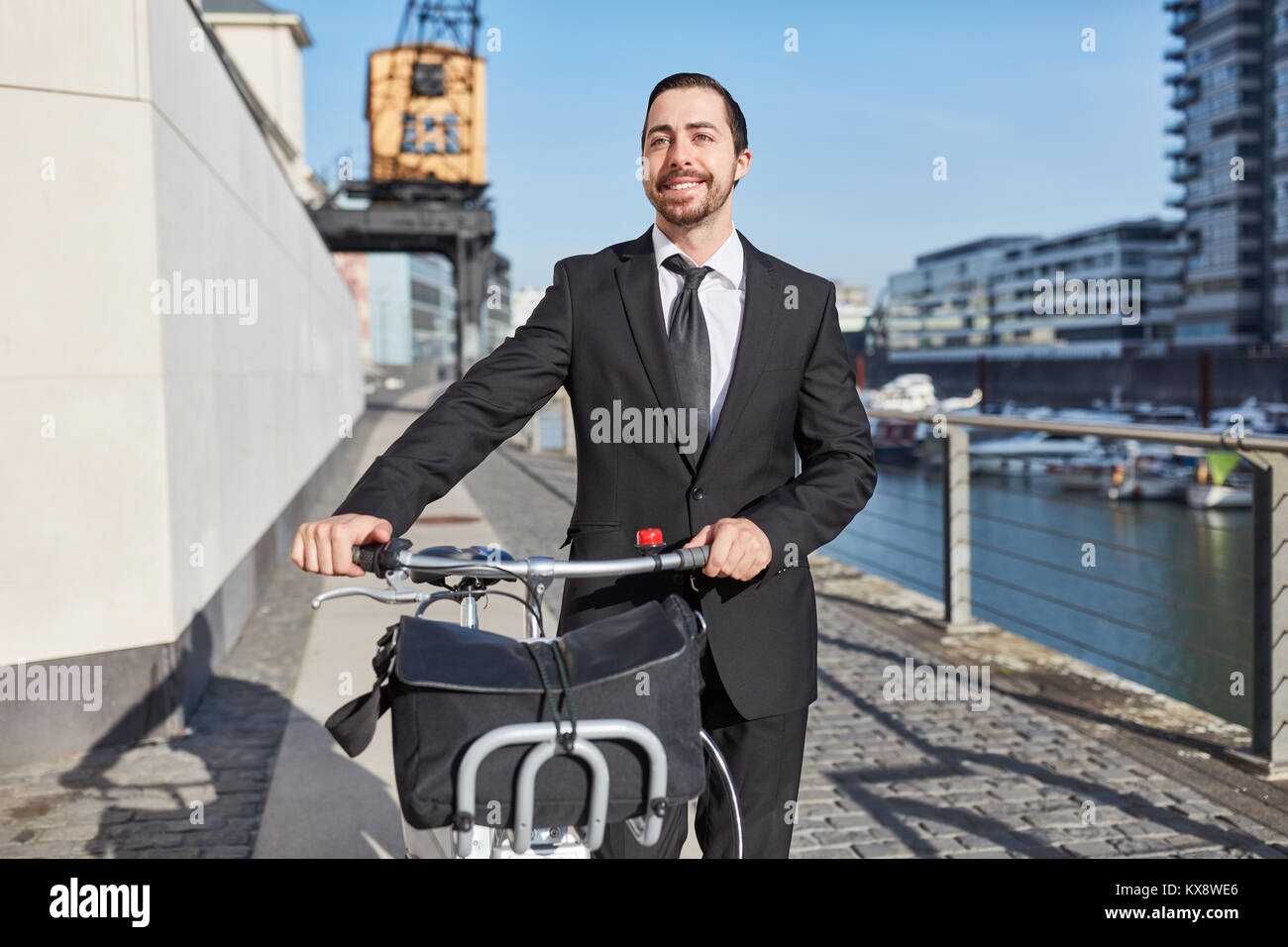 Eco-friendly startup imprenditore spinge una bici attraverso la città Foto Stock