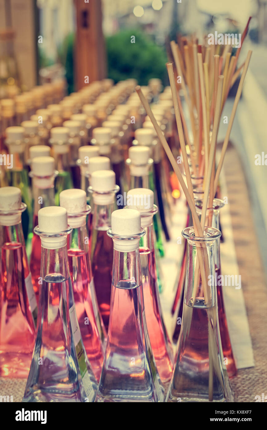 Bottiglie colorate di fragranze con bastoni per la fragranza della casa. Foto Stock