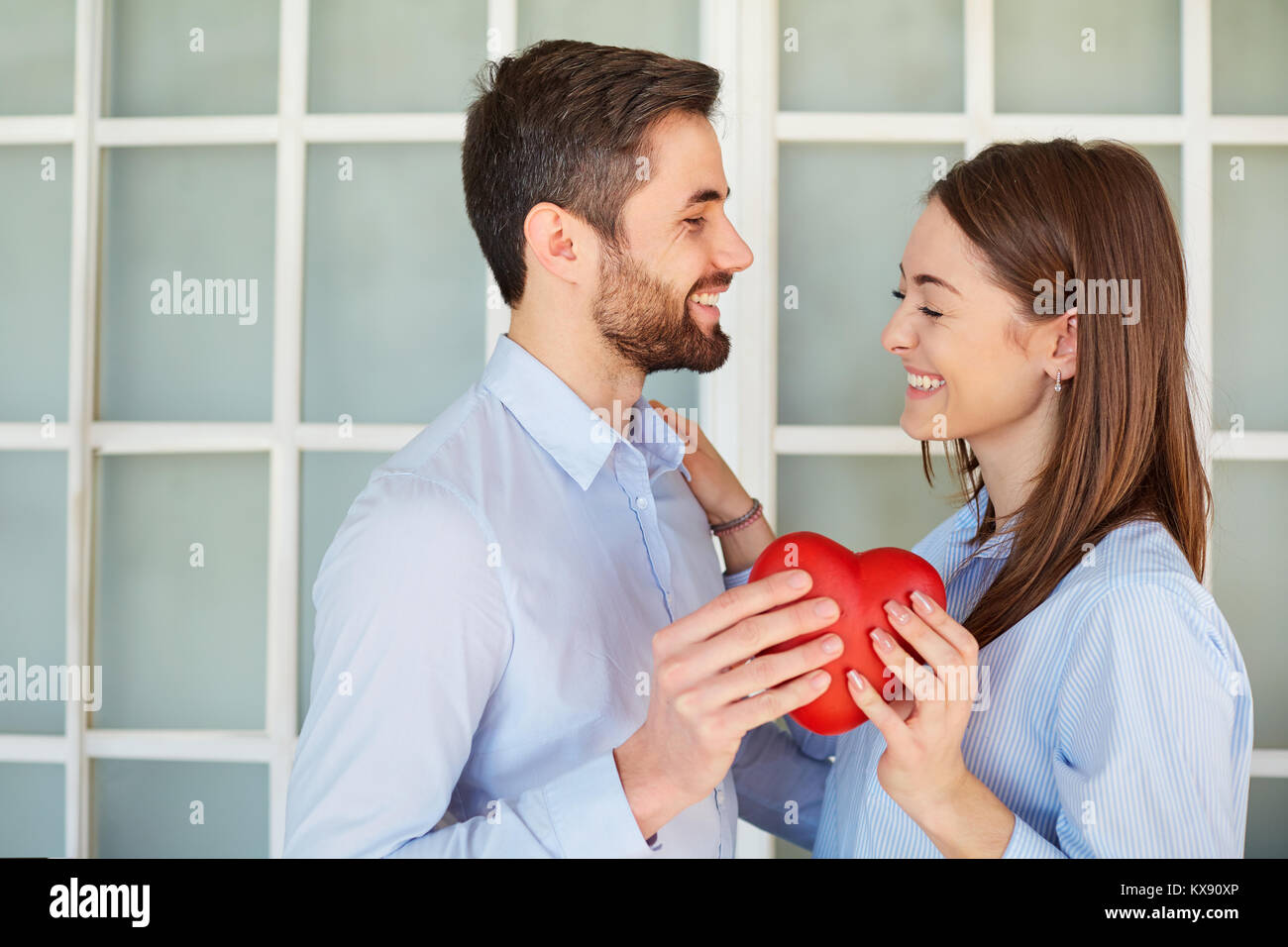 Un amorevole giovane con un cuore rosso ridere. Foto Stock