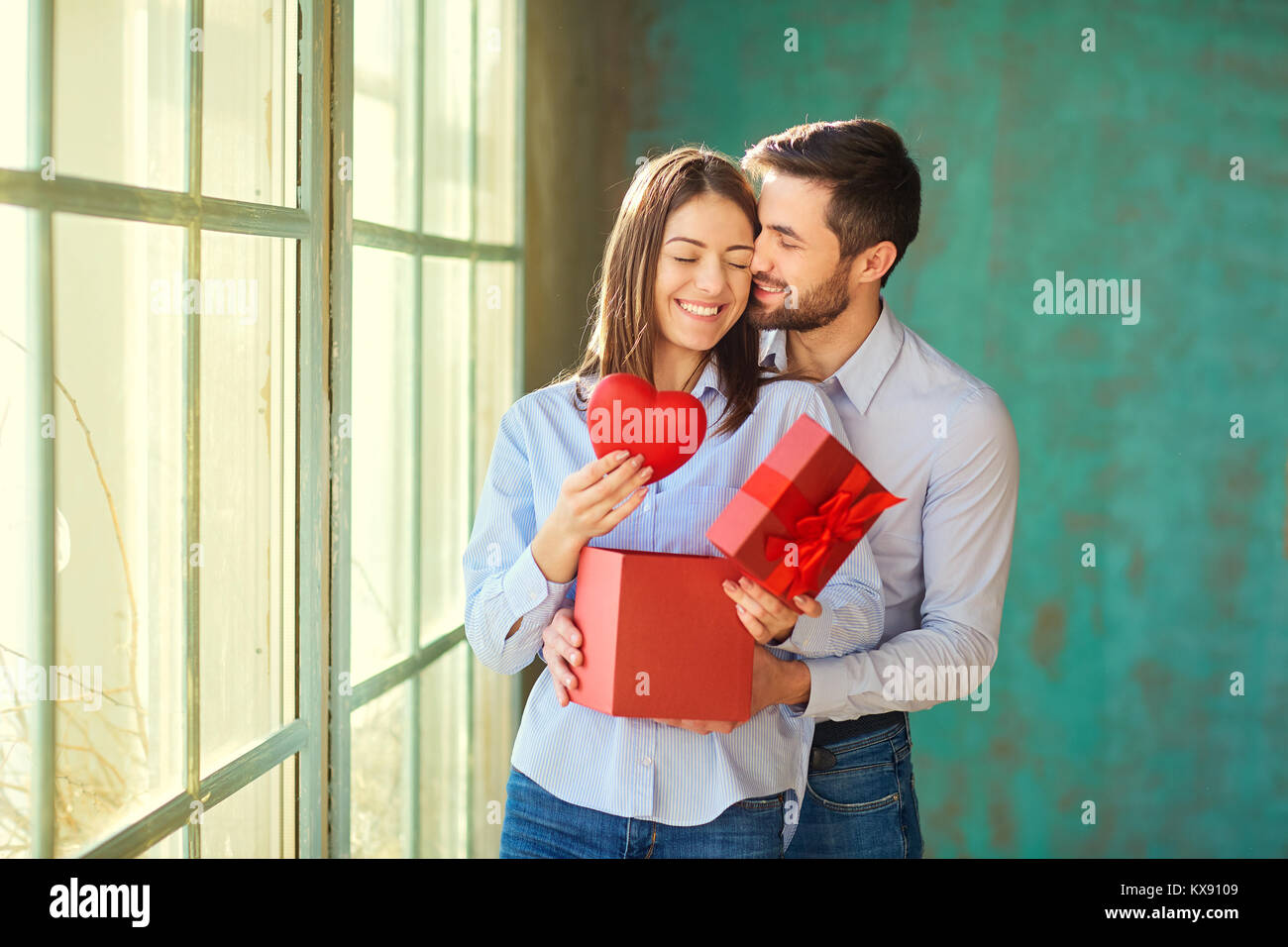 Un amorevole giovane con un cuore rosso sorridente. Foto Stock