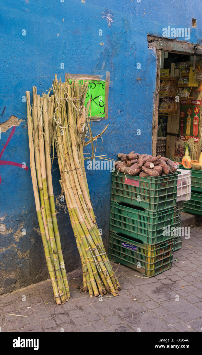 Mercato locale con blu di squallidi muri esterni, pavimento in pietra, casse di cibo, scorte di bambù e una visione ristretta del mercato interno, a Guanajuato Foto Stock