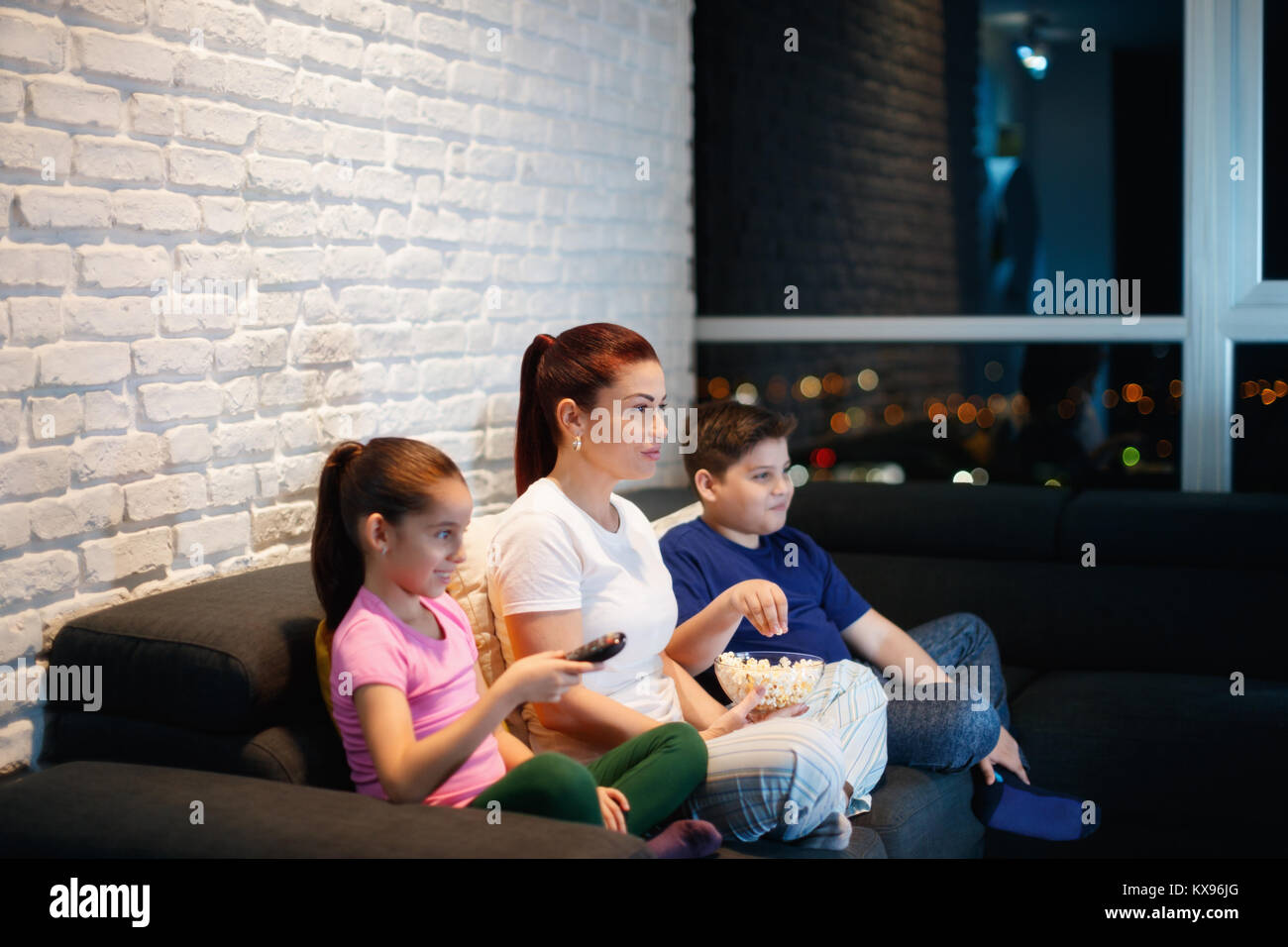 Madre Single e ai bambini di guardare la TV di notte Foto Stock