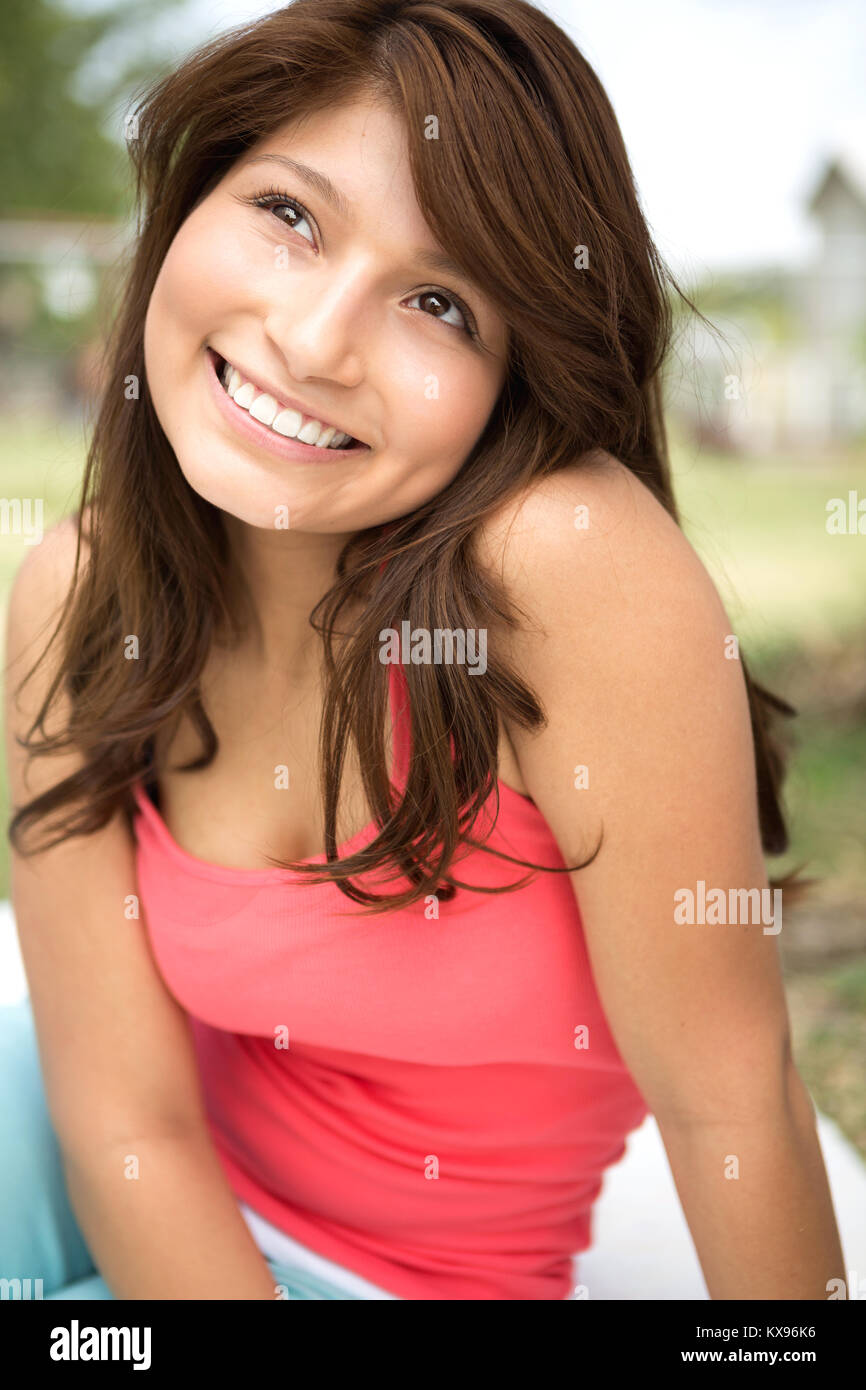 Giovane ragazza ispanica sorridente al di fuori. Foto Stock