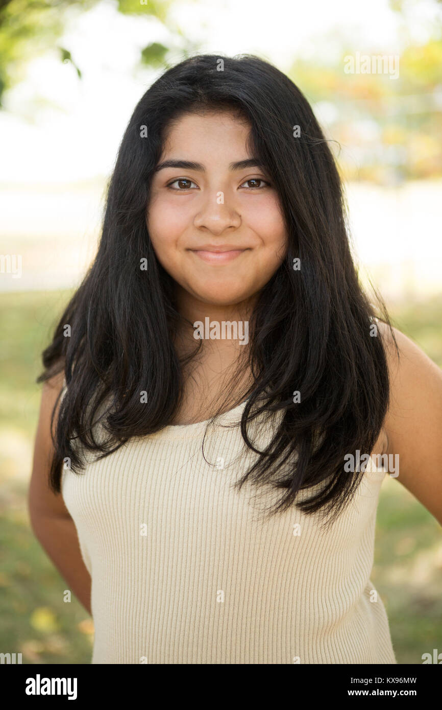 Giovane ragazza ispanica sorridente al di fuori. Foto Stock