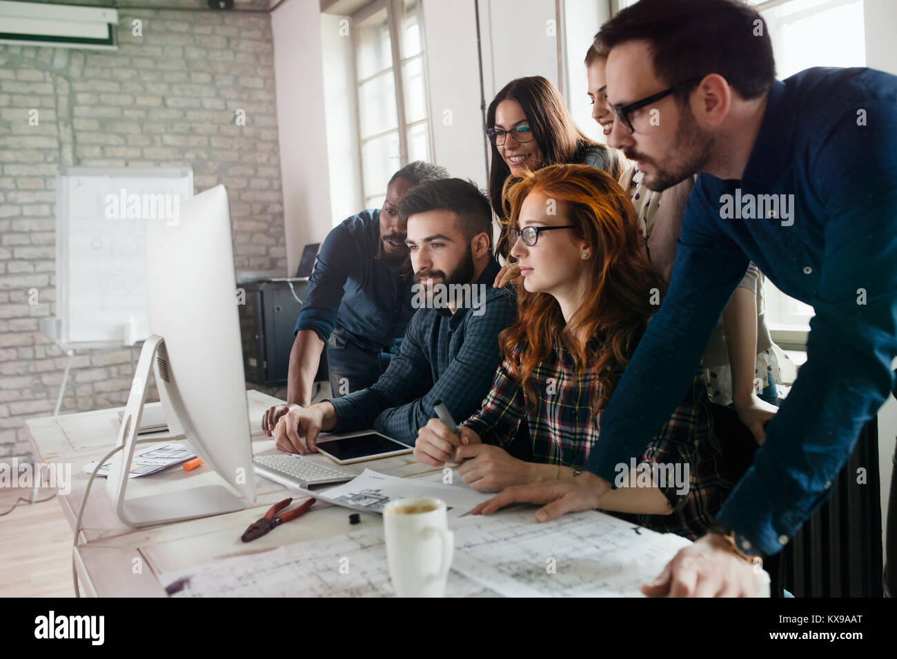 Un gruppo di giovani progettisti che lavorano come team Foto Stock