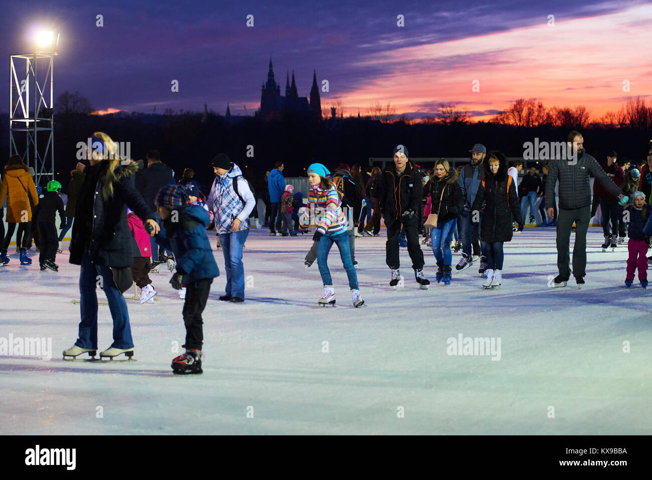 Praga, Repubblica Ceca - Gennaio 06, 2018: Pattinatori pattinaggio su un pubblico pista di pattinaggio su ghiaccio con uno sfondo del Castello di Praga in Letna Park Foto Stock