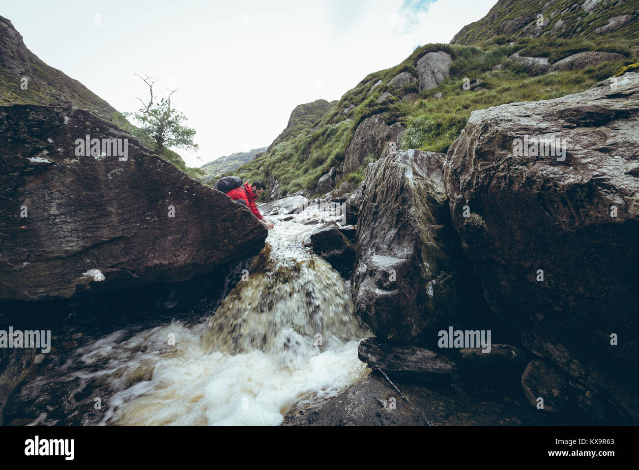 Escursionista acqua potabile dal flusso Foto Stock