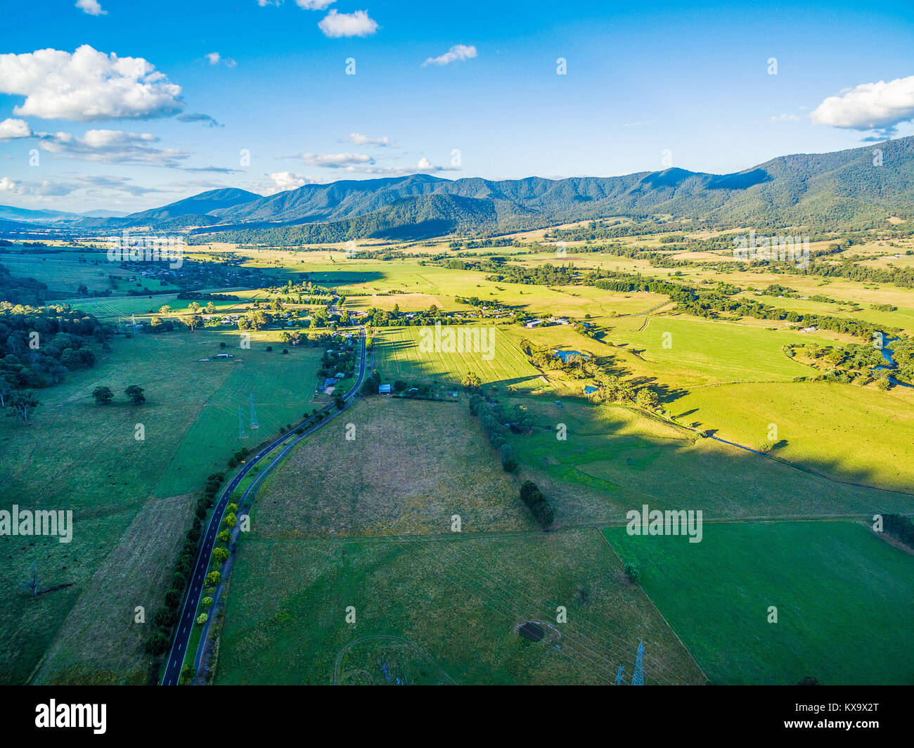 Vista aerea di campi agricoli in Australian alpi e autostrada rurale al tramonto Foto Stock