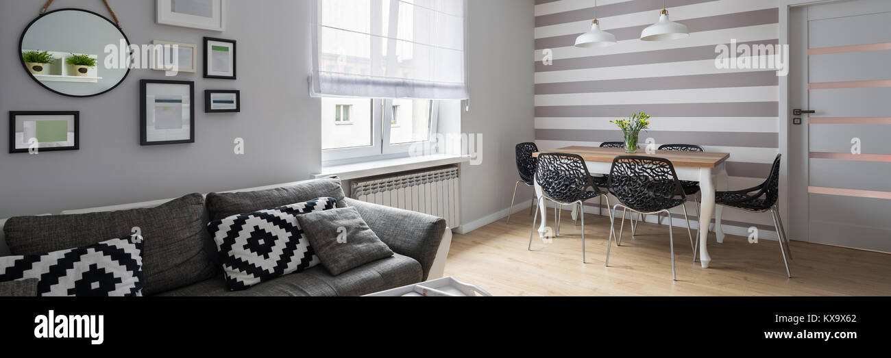 Home interno con moderno edificio grigio divano e tavolo da pranzo, panorama Foto Stock