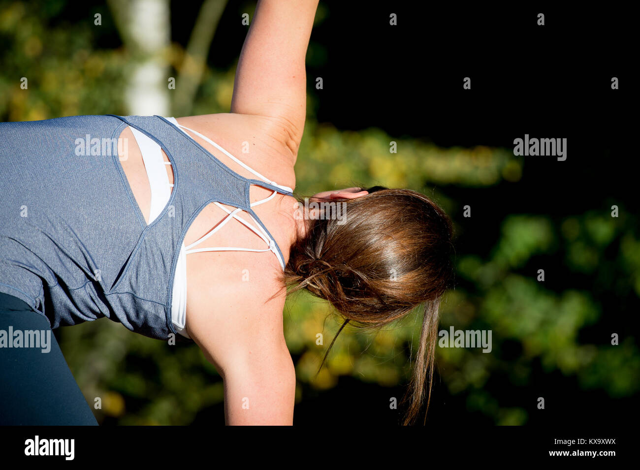 La donna a praticare yoga nella sabbia - triangolo pongono - Utthita Trikonasana - giorni di autunno Foto Stock