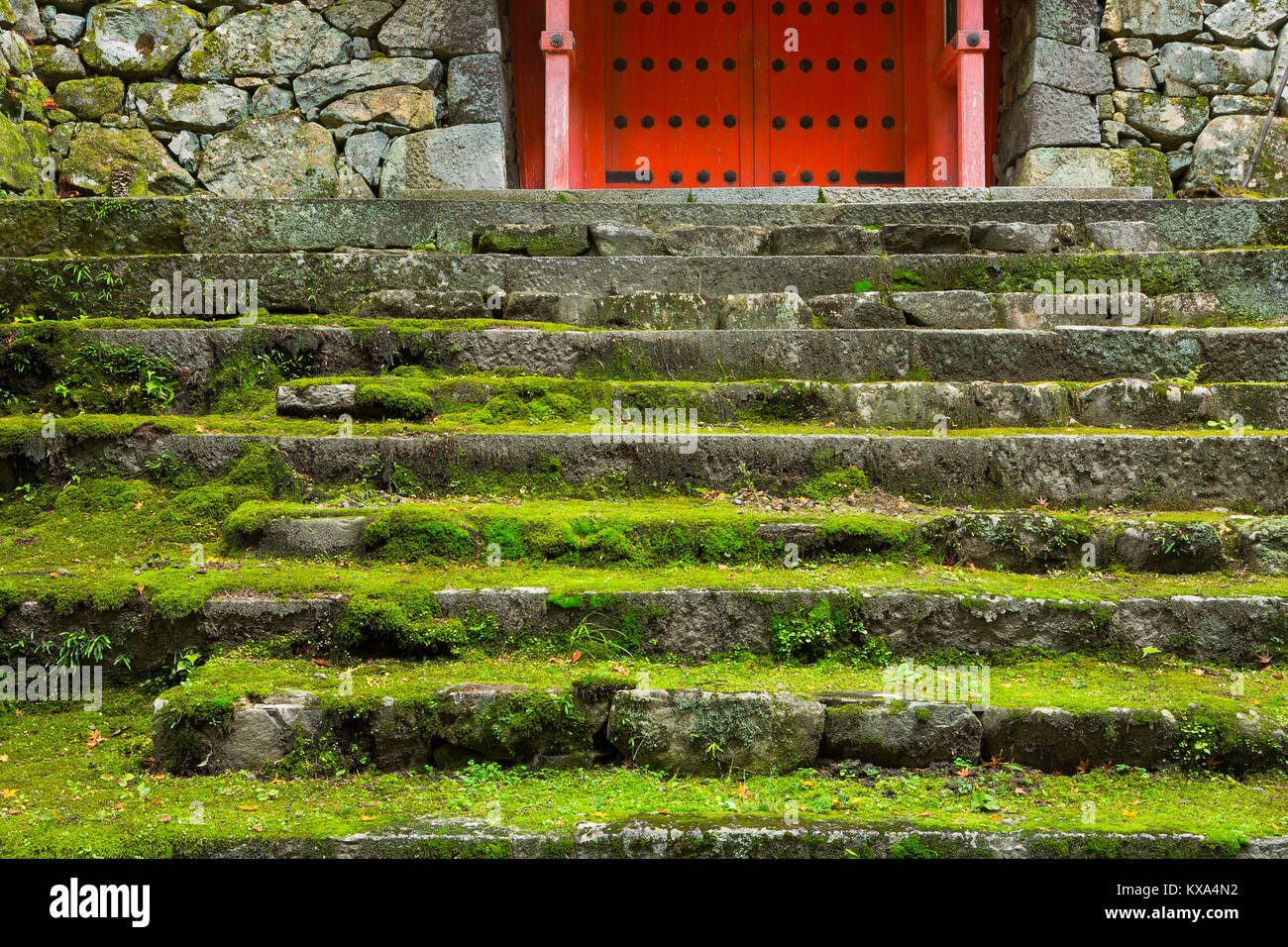 Le scale conducono ad una porta rossa a un tempio in Ohara, Giappone. Foto Stock