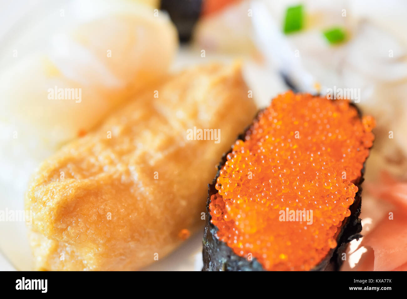 Primo piano di un assortimento di sushi. Compresi i salmoni roe sushi e pelle beancurd sushi. Foto Stock