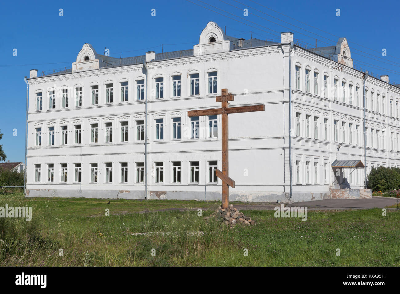 Croce di culto in commemorazione di tutti perso i templi della città di Belozersk sullo sfondo l'industrial-pedagogico college Belozersky Cremlino Vol Foto Stock