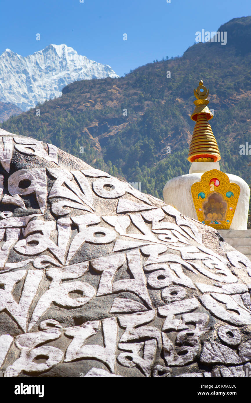 Un monumento Buddista sulla strada per il campo base Everest. Mani pareti con mantra, uno stupa e bandiere di preghiera. In serata sarete ricompensati con una deliziosa cucina nepalese attorno alla sala da pranzo fire sorseggiando un tè Sherpa e conversare con altri like-minded viaggiatori. Foto Stock