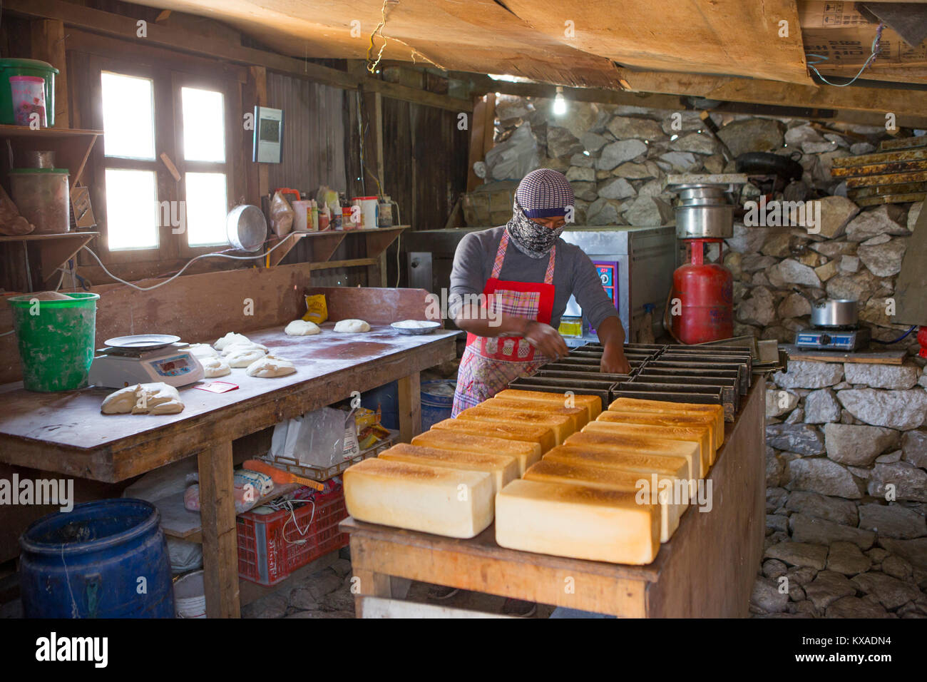 Un abitante di Pangboche è la cottura del pane in un capannone della famosa panetteria. Questa catena ha un paio di negozi nella Valle del Khumbu, servendo il pane appena sfornato e dolci per escursionisti e alpinisti sulla strada per il Monte Everest. Foto Stock