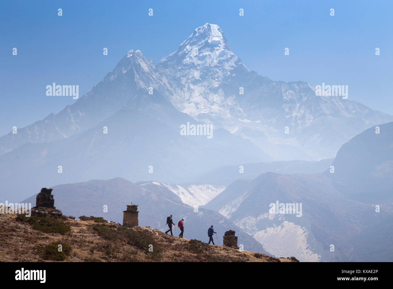 Tre escursionisti discendente da Pangboche monastero per continuare la loro escursione verso il Campo Base Everest, in background Ama Dablam montagna. Foto Stock