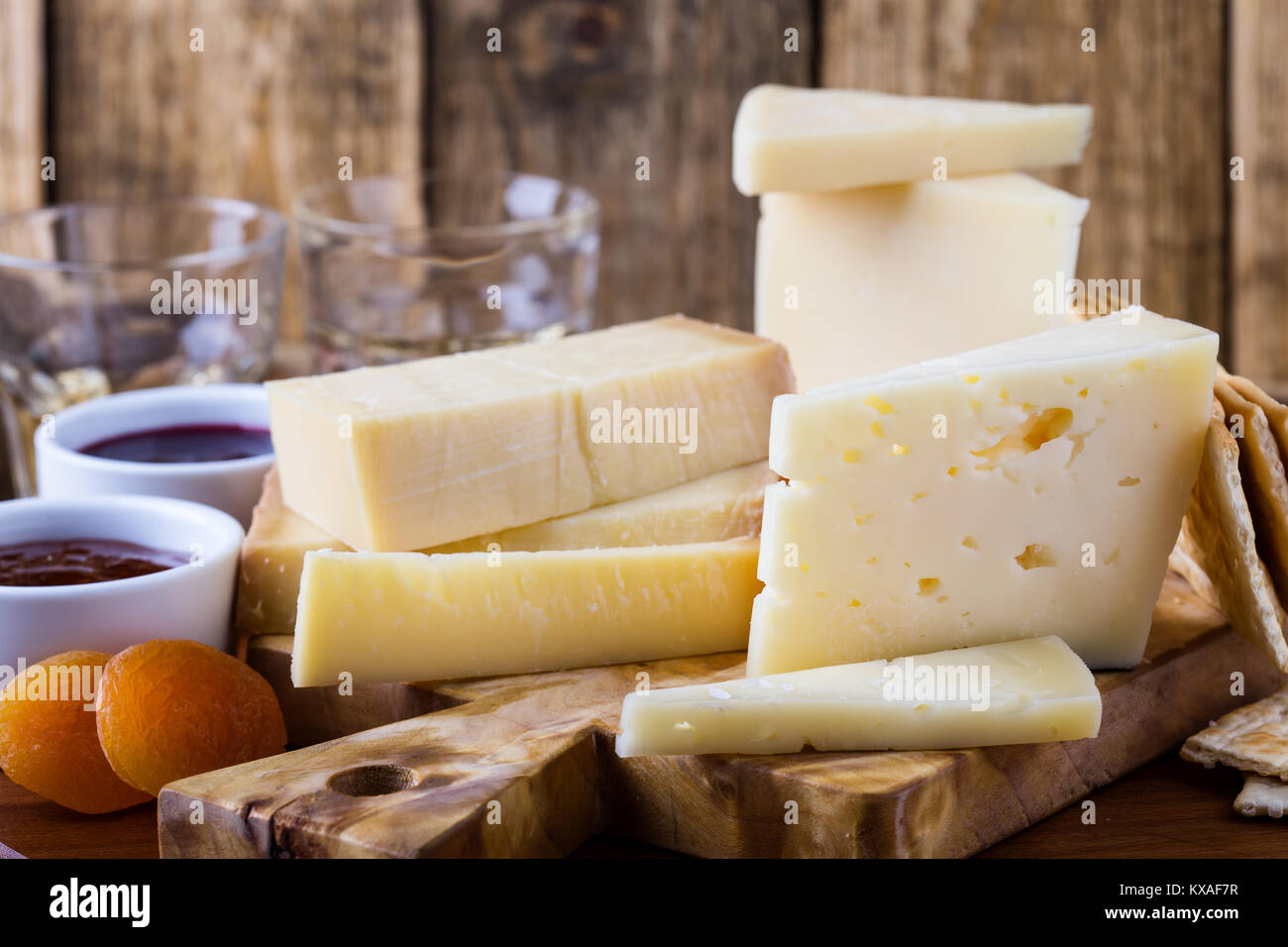 Formaggi, marmellata di frutta, noci e vino sul tagliere di legno, delizioso antipasto di vacanze Foto Stock