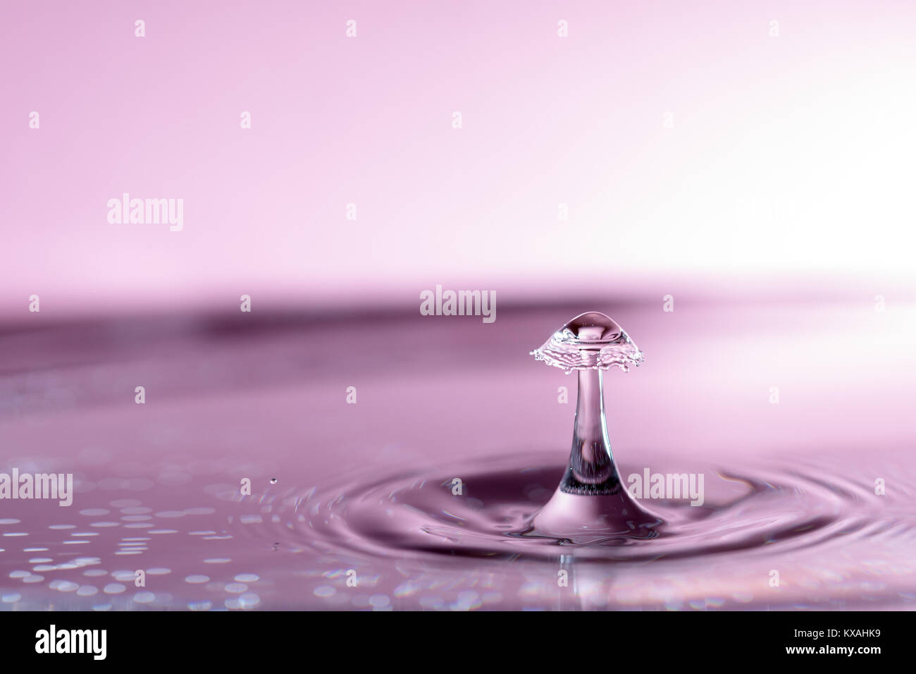 Fotografia di goccioline di acqua con uno sfondo colorato. Noto anche come goccioline di acqua di collisione. Foto Stock
