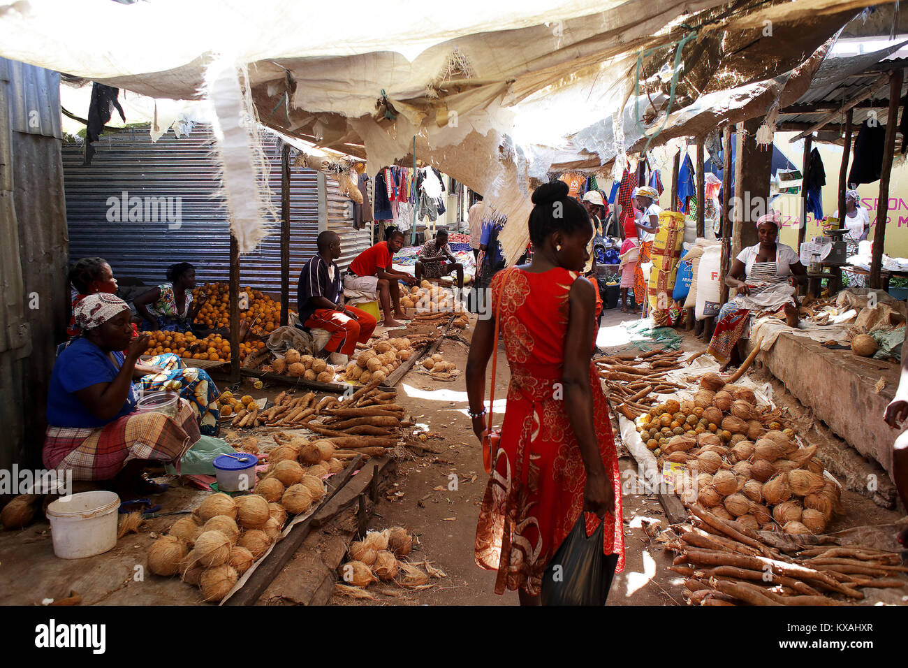 Gente che vende le radici e noci di cocco in città mercato, Mozambico Foto Stock