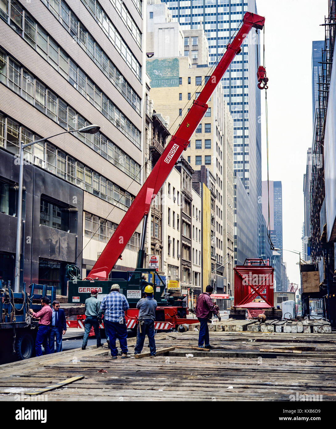 New York 1980s, lavoratori edili che istituiscono una gru da costruzione rossa, a metà strada, Midtown, Manhattan, New York City, NY, NEW YORK, STATI UNITI, Foto Stock