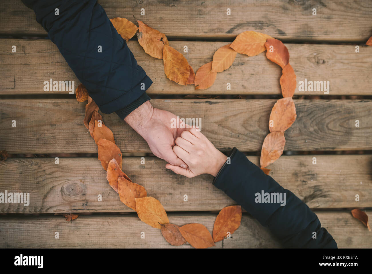 Una giovane coppia di toccare le mani a una tabella.Il giorno di San Valentino del concetto. Foto Stock
