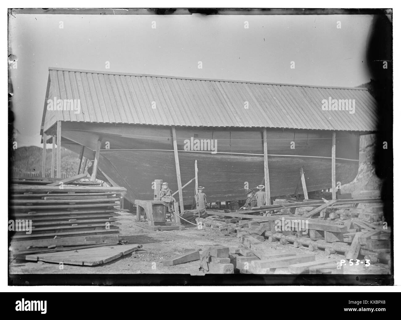 La fotografia mostra lo scafo in legno della nave Skøyte Anden su uno scalo per la riparazione o la costruzione in Norvegia, datato tra il 1900 e il 1910, che cattura un cantiere marittimo con impalcature e supporti in legno. Foto Stock