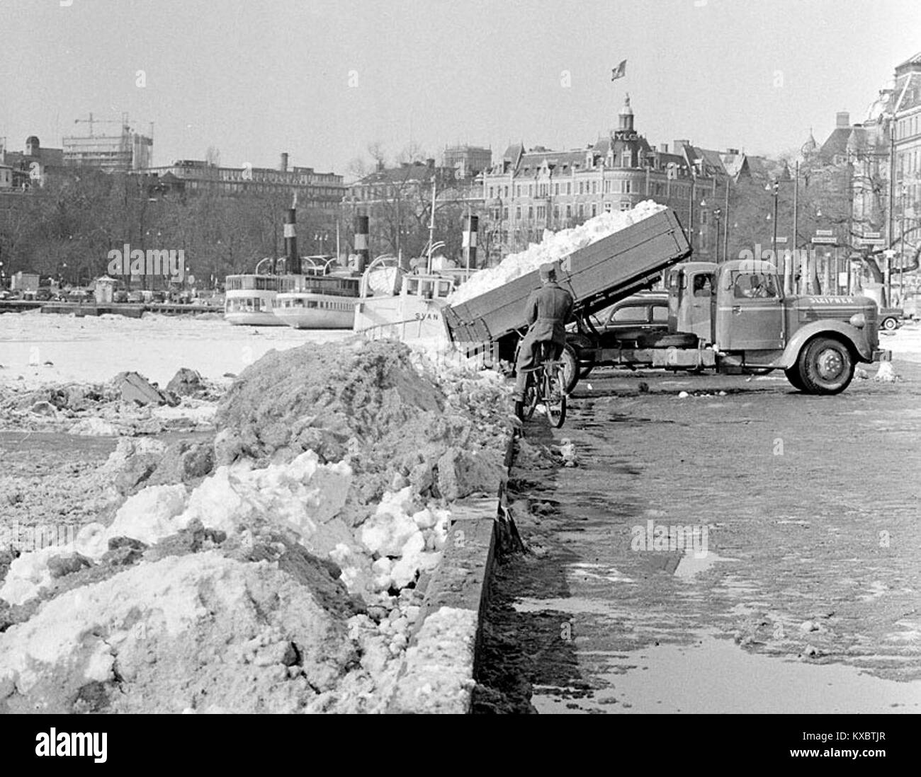 Fotografia del 1958 che mostra le operazioni di scarico della neve in Svezia, illustrando le pratiche di manutenzione invernale e di gestione urbana della metà del XX secolo. Foto Stock