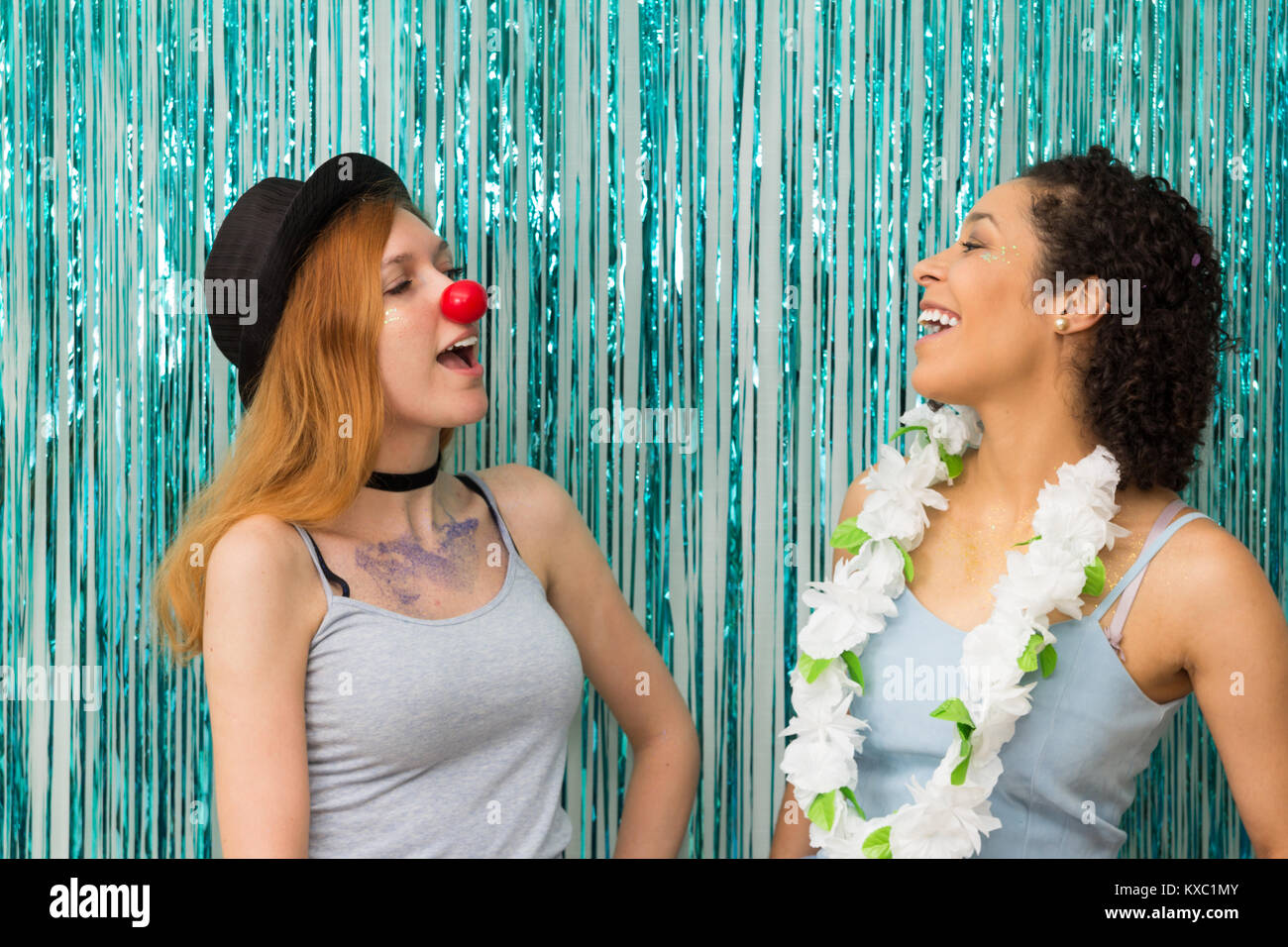 Due amici divertirsi a Carnevale. Uno è che indossa il clown naso e le  altre Collane Hawaiane. La predominanza del colore blu. Le donne svolgono  coriandoli e giggl Foto stock - Alamy