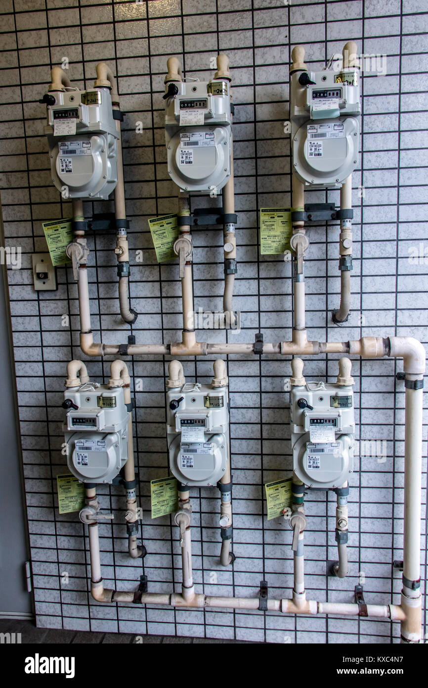 Giappone, TOKYO, Giu 28 2017, gruppo di contatori del gas appendere su una parete in corrispondenza della voce di apartment house. Fila di Gas Naturale metri con tubazione in costruzione. Foto Stock