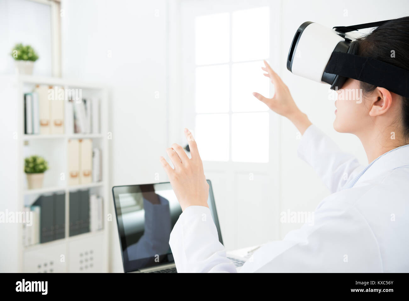 Bellezza giovane medico donna che indossa la tecnologia VR guardando gli occhiali 3D e video usando le mani organizzata documento Relazione sulla schermata di simulazione. Foto Stock