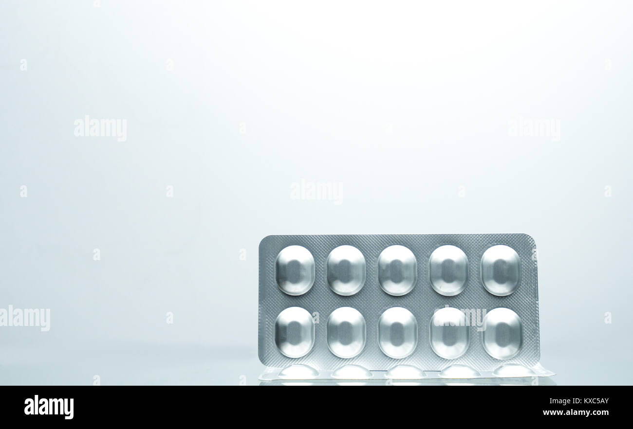 Foglio di alluminio argentato blister di pillole con su sfondo bianco con ombre e copia di spazio per il testo. Gli imballaggi di prodotti farmaceutici e di medicina stora Foto Stock