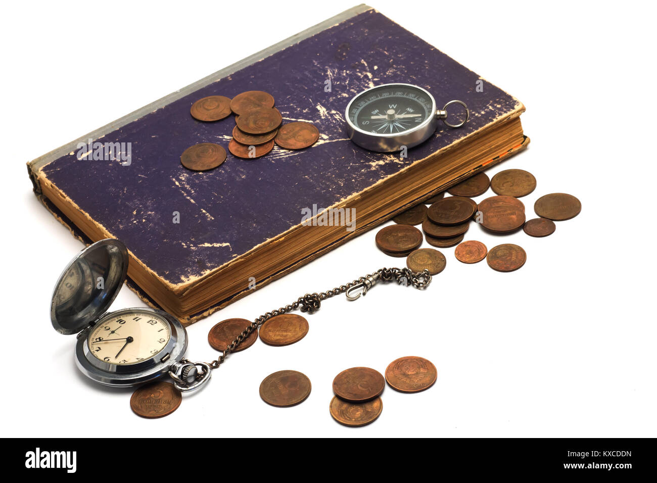 Vecchio orologio,monete, libro e bussola su sfondo bianco Foto Stock