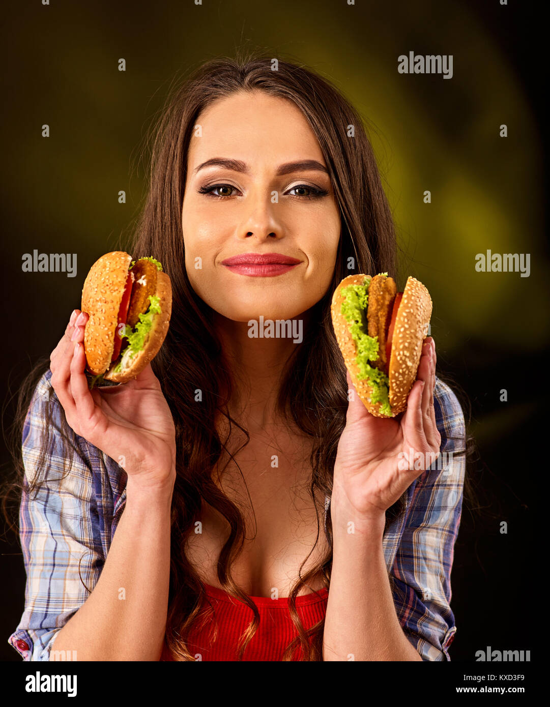 Donna di mangiare hamburger. Ragazza morso del grande burger Foto Stock