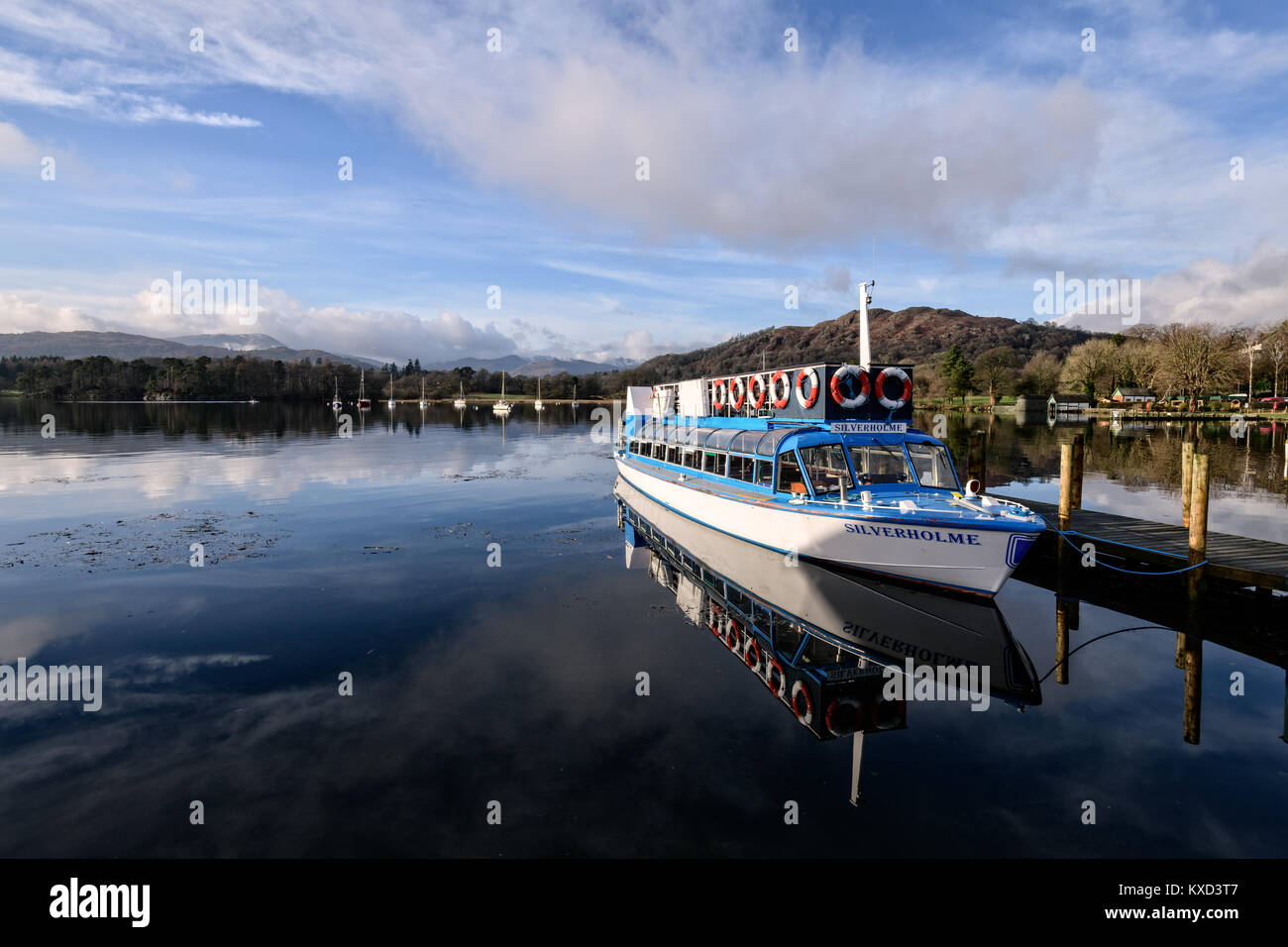 Lago di Windermere cruiser con specchio-simili riflessioni su una bella e soleggiata giornata invernale e Foto Stock