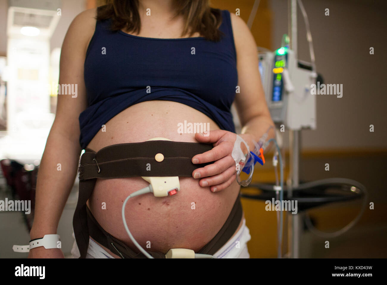 Sezione mediana della donna incinta avente contrazione stress test permanente, mentre in ospedale Foto Stock